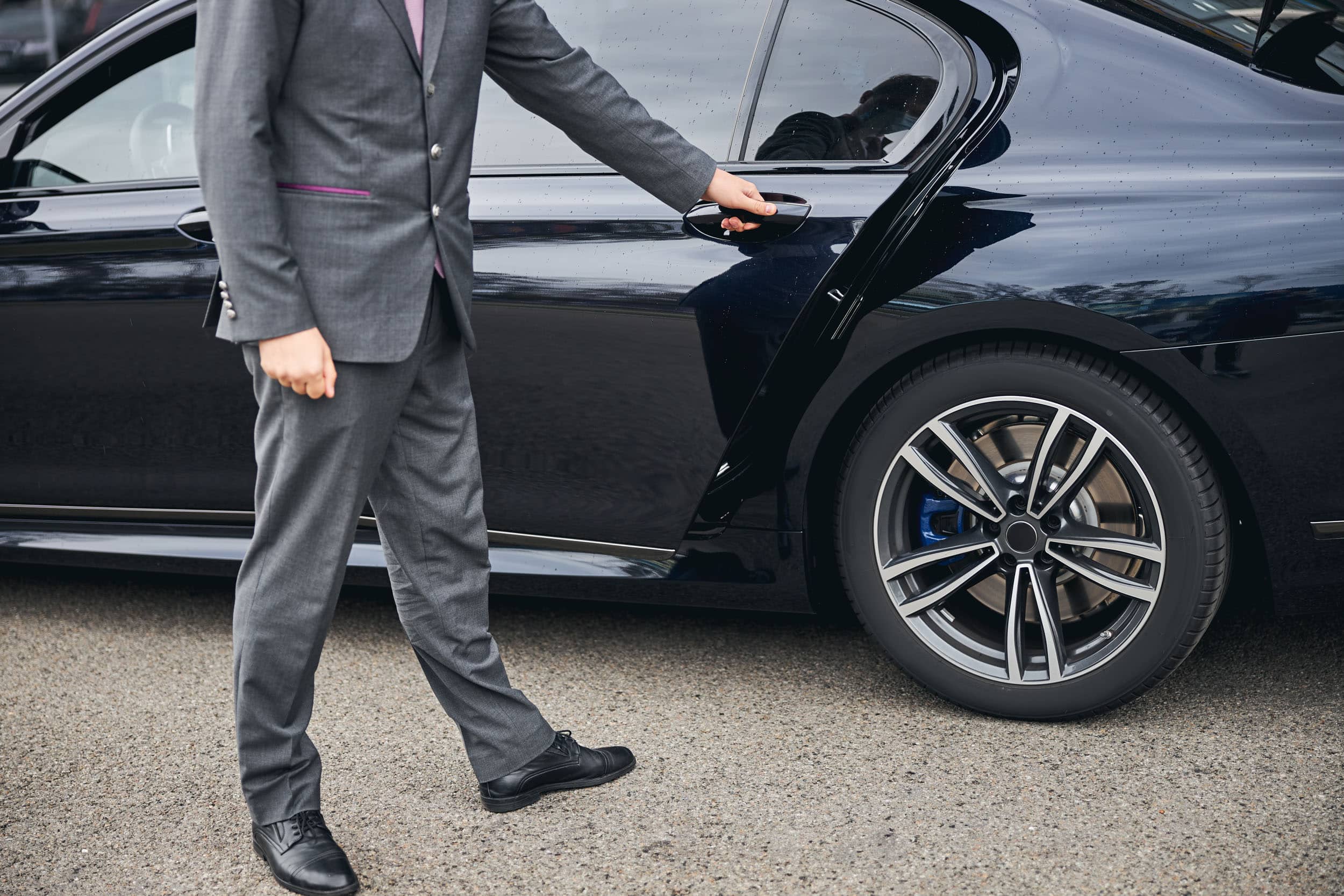 chauffeur privé qui ouvre la porte arrière d'un véhicule