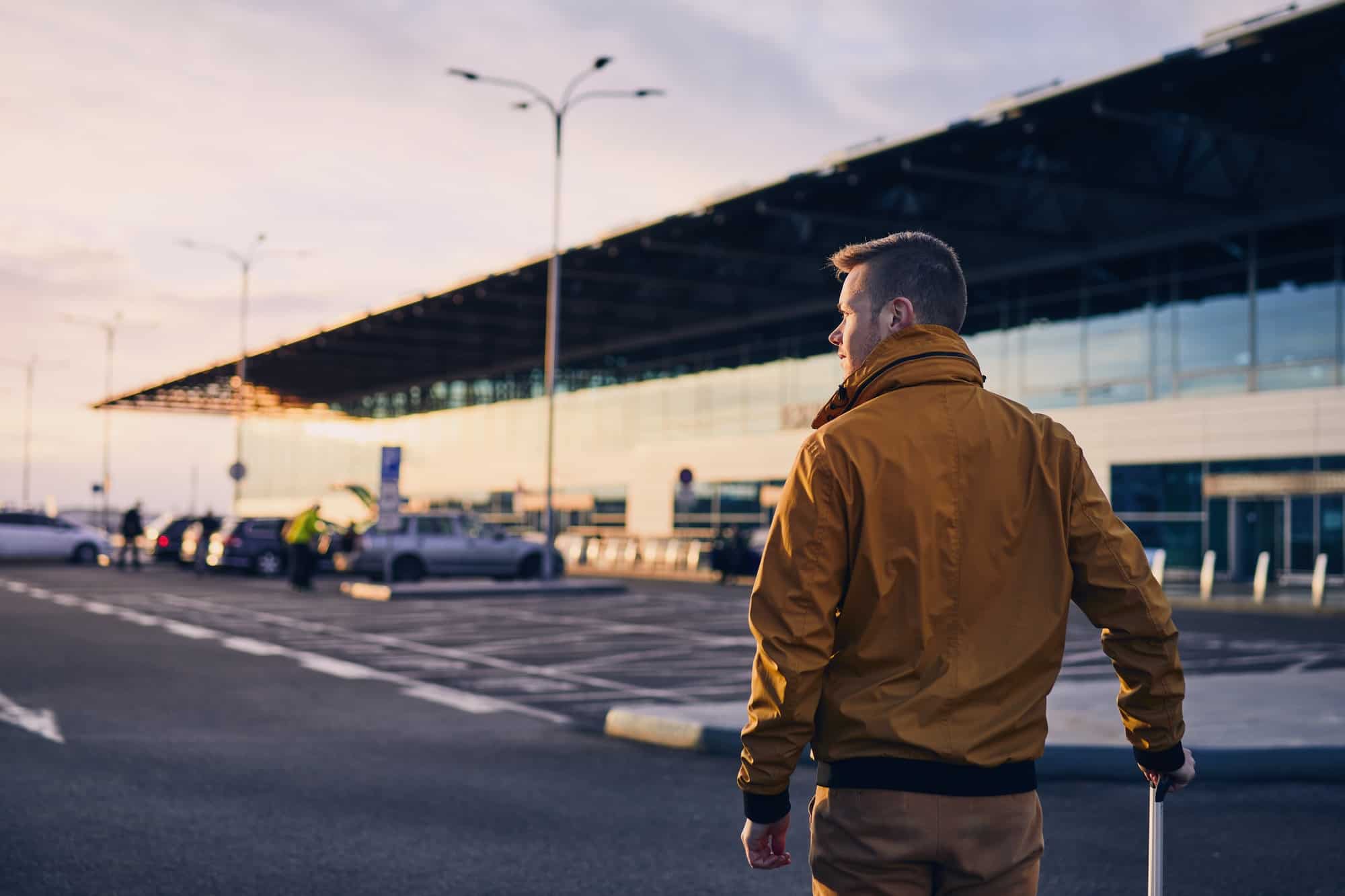 homme qui regarde le couché de soleil à l'aéroport